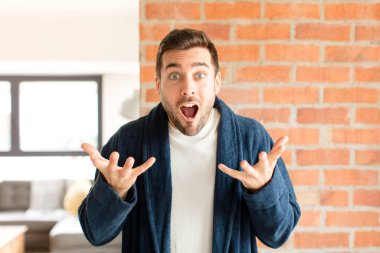 Yakışıklı bir adam son derece şok olmuş ve şaşırmış, endişeli ve paniklemiş, stresli ve dehşete kapılmış görünüyor.