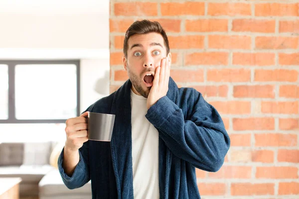 ハンサムな男はショックを受けて怖がって頬に口や手を開けて怯え — ストック写真