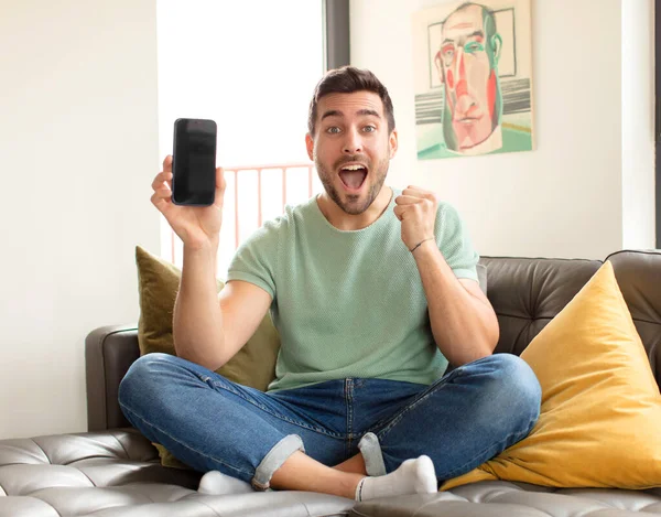 Yakışıklı adam şoke olmuş, heyecanlı ve mutlu, gülüyor ve başarıyı kutluyor.!