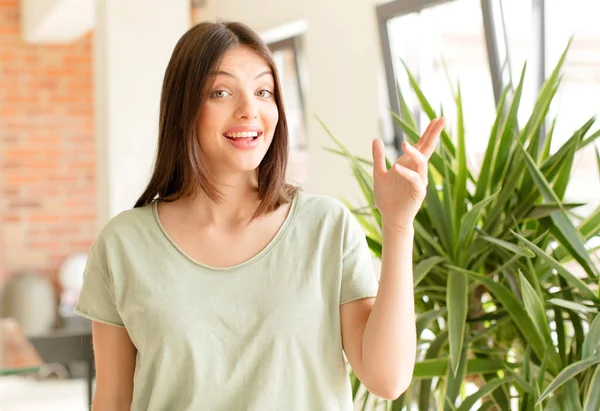 Güzel bir kadın mutlu, şaşırmış ve neşeli, pozitif bir tavırla gülümseyen, bir çözüm ya da fikir gerçekleştiren.