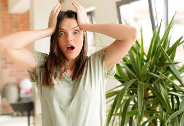 Güzel bir kadın dehşete kapılmış ve şok olmuş hissediyor, ellerini havaya kaldırıyor ve bir hata yüzünden panikliyor.