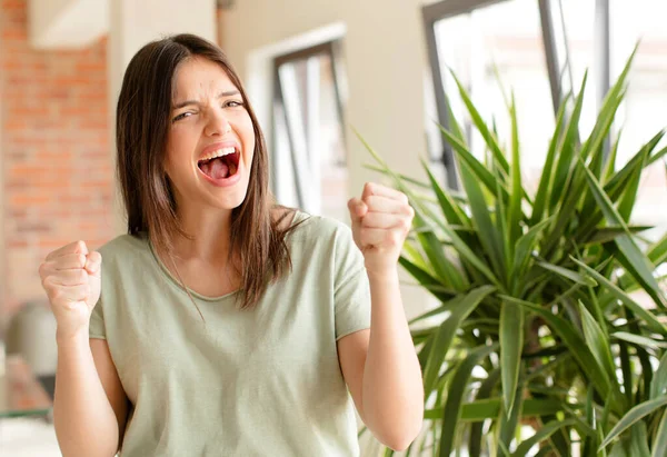 Güzel bir kadın mutlu, pozitif ve başarılı hissediyor, zaferi, başarıları ya da iyi şansı kutluyor.