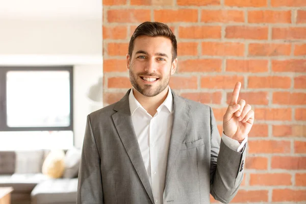 Homem Negócios Bonito Sorrindo Olhando Amigável Mostrando Número Primeiro Com — Fotografia de Stock