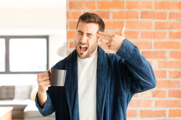 英俊的男人看上去很不高兴 很紧张 手拿着枪 指着头 做着自杀手势 — 图库照片