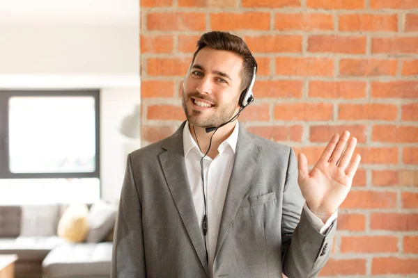 Handsome Telemarketer Smiling Happily Cheerfully Waving Hand Welcoming Greeting You — Stock Photo, Image