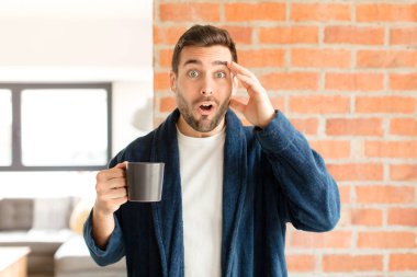 Yakışıklı adam mutlu, şaşkın ve şaşırmış görünüyor, gülümsüyor ve inanılmaz ve inanılmaz iyi haberleri fark ediyor.