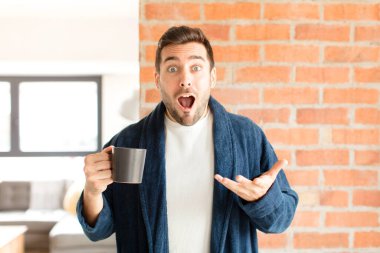 Yakışıklı, ağzı açık ve şaşırmış, şok olmuş ve hayrete düşmüş bir adam.