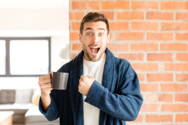 Yakışıklı adam mutlu, pozitif ve başarılı hissediyor, bir meydan okumayla karşılaştığında motive oluyor veya iyi sonuçları kutluyor.