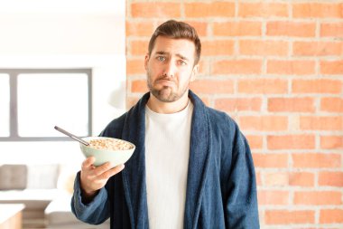 Yakışıklı bir adam üzgün ve mızmız, mutsuz bir bakışla, olumsuz ve hayal kırıklığına uğramış bir tavırla ağlıyor.