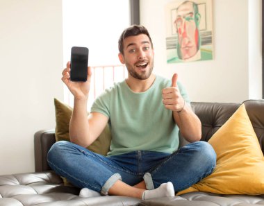 Yakışıklı, gururlu, tasasız, kendinden emin ve mutlu, olumlu gülümseyen bir adam.