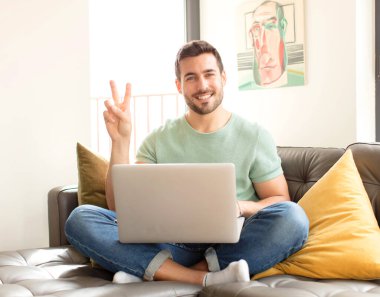 Yakışıklı adam gülümsüyor ve arkadaş canlısı görünüyor. İki ya da iki numarayı gösteriyor. Elleri önde, geriye doğru sayıyor.