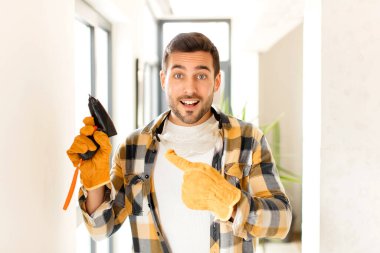 Ustabaşı heyecanlı ve şaşırmış görünüyor. Yana ve yukarıya uzayı gösteriyor.