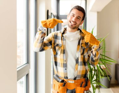 Becerikli adam kendine güvenerek gülümseyerek kendi geniş gülümsemesine olumlu, rahat, tatmin olmuş tavrına işaret ediyor.