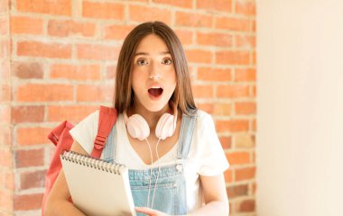 Şok olmuş ya da şaşırmış görünüyor, ağzı açık bakıyor ve 