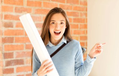 Güzel mimar heyecanlı ve şaşırmış görünüyor. Yana ve yukarıya doğru uzayı gösteriyor.