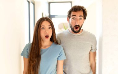 Genç çift şok olmuş ya da şaşırmış görünüyor, ağzı açık bir şekilde 