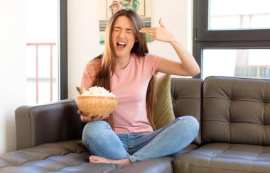 Mutsuz ve stresli görünüyor, intihar jesti elle silah işareti yapıyor, kafasını işaret ediyor.