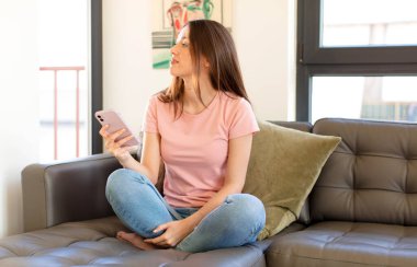 Profil görünümündeki güzel kadın ileriyi kopyalamak istiyor, düşünüyor, hayal ediyor ya da hayal kuruyor.