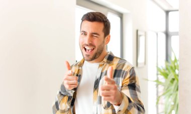 Yakışıklı adam kendini mutlu, havalı, tatmin olmuş, rahat ve başarılı hissediyor, kameraya bakıyor, seni seçiyor.