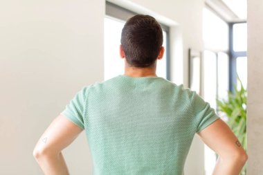 Yakışıklı bir adam kafası karışık ya da dolu hisseder ya da şüphe ve sorular, merak eder, elleri kalçasında, dikiz aynasından