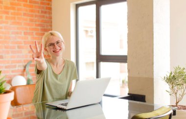 Güzel bir öğrenci gülümsüyor ve arkadaş canlısı görünüyor. İki ya da iki numarayı gösteriyor. Elleri önde, geri sayıyor.