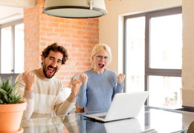 Genç çift öfkeli bir ifadeyle ya da yumruklarıyla bağırarak başarıyı kutluyor.