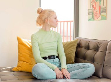 Profil görünümündeki güzel kadın ileriyi kopyalamak istiyor, düşünüyor, hayal ediyor ya da hayal kuruyor.