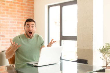 Yakışıklı, ağzı açık ve şaşırmış, şok olmuş ve hayrete düşmüş bir adam.