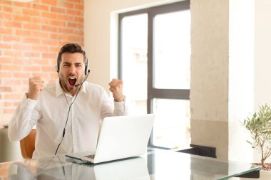 Yakışıklı pazarlamacı sinirli bir ifadeyle agresif bir şekilde bağırıyor ya da yumruklarıyla başarıyı kutluyor.