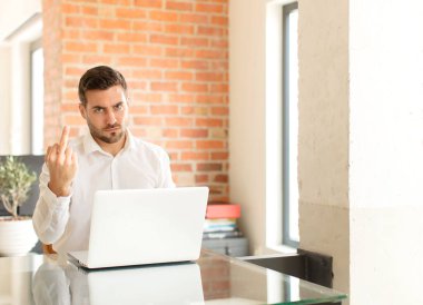 Yakışıklı iş adamı kızgın, sinirli, asi ve agresif hissediyor, orta parmağını sallıyor, karşı koyuyor.