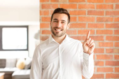 Yakışıklı iş adamı gülümsüyor ve arkadaş canlısı görünüyor. Bir numara ya da ilk eli önde, geriye doğru sayıyor.