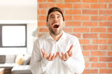 Yakışıklı iş adamı umutsuz ve hayal kırıklığına uğramış görünüyor, stresli, mutsuz ve sinirli, bağırıyor ve çığlık atıyor.