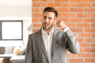 Yakışıklı iş adamı kafası karışık ve şaşkın hissediyor. Deli, deli ya da aklını kaçırmış olduğunu gösteriyor.