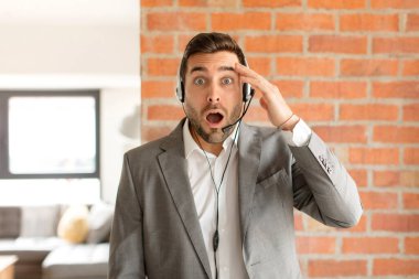 Yakışıklı pazarlamacı mutlu, şaşkın ve şaşırmış görünüyor, gülümsüyor ve inanılmaz ve inanılmaz iyi haberleri fark ediyor.