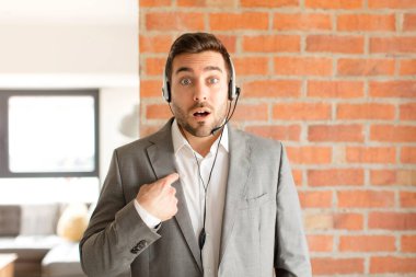 Yakışıklı pazarlamacı ağzı açık, kendini işaret eden bir şekilde şaşkın ve şaşırmış görünüyordu.