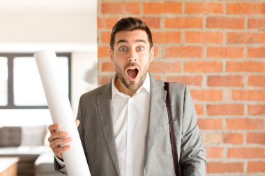 Yakışıklı mimar çok şaşırmış ya da şaşkın görünüyor, ağzı açık bir şekilde 