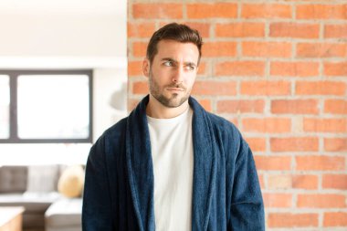 Yakışıklı bir adam üzgün, üzgün ya da kızgın. Olumsuz bir tavır sergiliyor, anlaşmazlık içinde kaşlarını çatıyor.