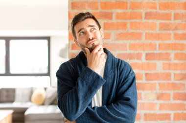 Yakışıklı düşünen, kuşkulu ve kafası karışık, farklı seçenekleri olan, hangi kararı vereceğini merak eden bir adam.