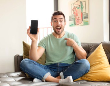 Yakışıklı adam mutlu, şaşkın ve gururlu, heyecanlı, şaşkın bakışlarla kendini işaret ediyor.