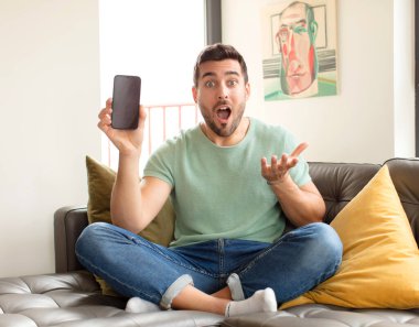 Yakışıklı bir adam son derece şok olmuş ve şaşırmış, endişeli ve paniklemiş, stresli ve dehşete kapılmış görünüyor.