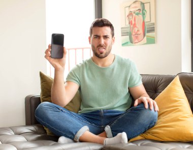 Yakışıklı bir adam tiksinmiş ve rahatsız olmuş hissediyor. Dilini dışarı çıkarıyor. Çirkin ve iğrenç bir şeyden hoşlanmıyor.