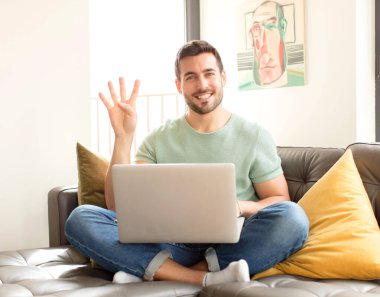 Yakışıklı adam gülümsüyor ve arkadaş canlısı görünüyor. Elleri önde, geriye doğru sayıyor.