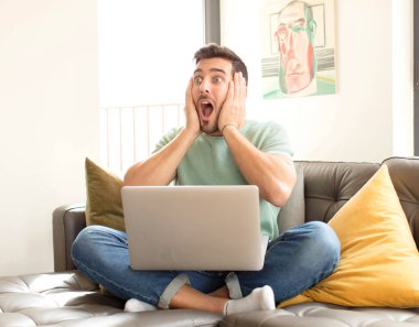 Yakışıklı adam mutlu, heyecanlı ve şaşırmış hissediyor, iki eli yüzü yana bakıyor.