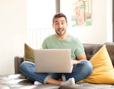 Yakışıklı adam mutlu ve hoş bir şekilde şaşırmış görünüyor. Büyülenmiş ve şok olmuş bir ifadeyle heyecanlanıyor.