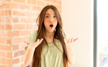 Güzel bir kadın son derece şok olmuş ve şaşırmış, endişeli ve panik içinde, stresli ve dehşete düşmüş bir bakışla