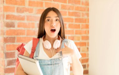 Şok olmuş ve şaşırmış bir halde, ağzı açık, kendini işaret eden.