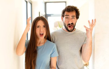 Genç çift ellerini havaya kaldırarak çığlık atıyor, öfkeli, sinirli, stresli ve üzgün hissediyorlar.