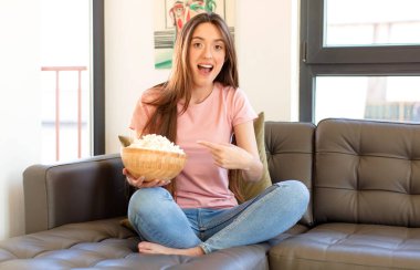 Heyecanlı ve şaşırmış görünüyor. Yana ve yukarıya bakıyor. Boşluğu kopyalıyor.