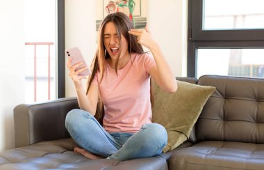 Güzel bir kadın mutsuz ve stresli görünüyor, intihar jesti elle silah işareti yapıyor, kafasını işaret ediyor.