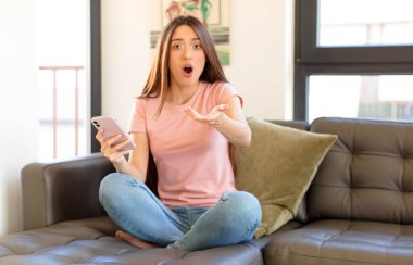 Güzel bir kadın son derece şok olmuş ve şaşırmış, endişeli ve panik içinde, stresli ve dehşete düşmüş bir bakışla